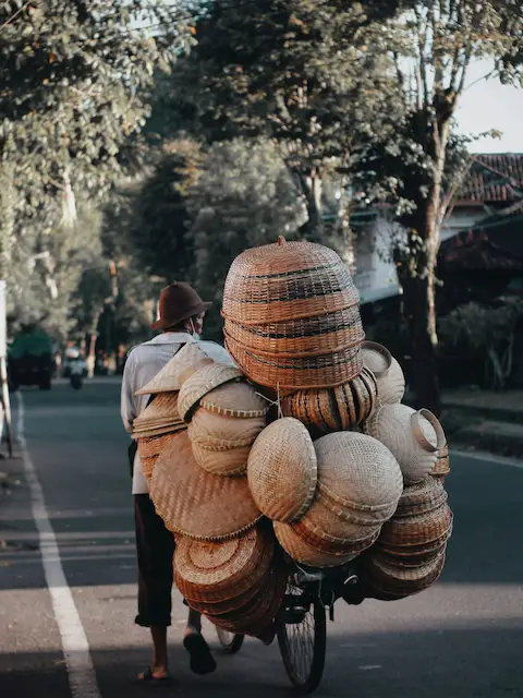 Merchant on bicycle with many hand-woven baskets on back