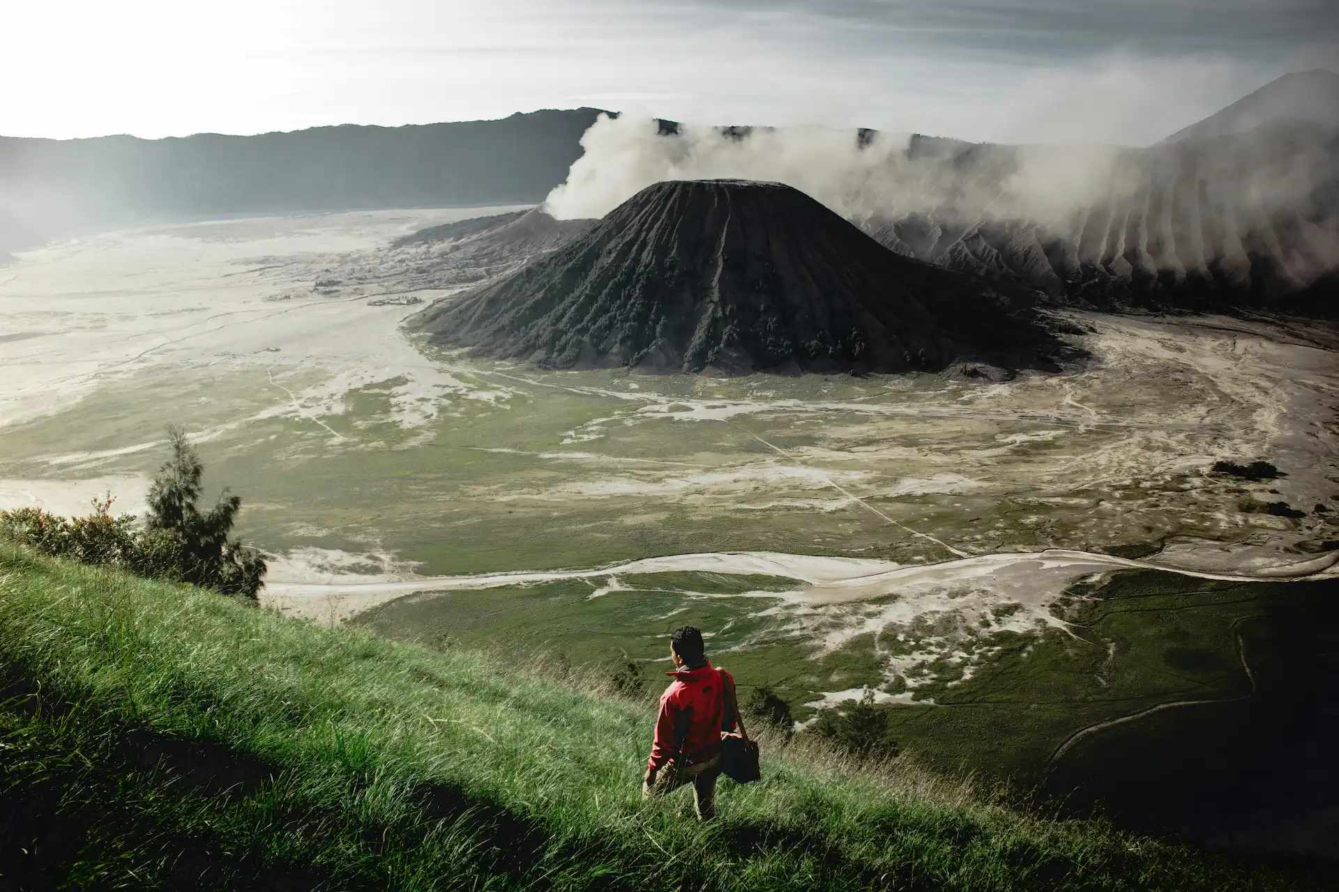 Aerial photo of man standing atop Mt. Bromo