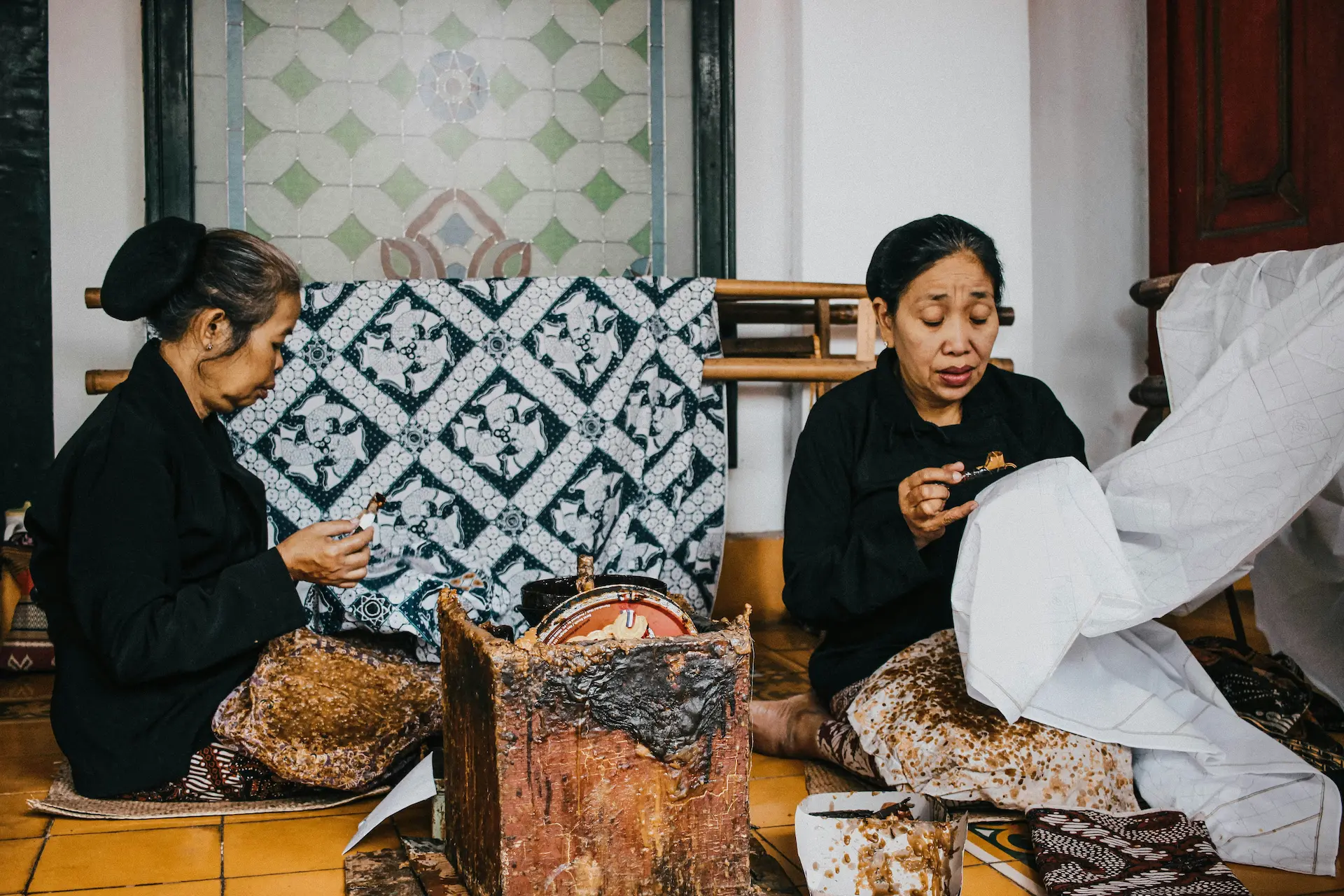 Two Indonesian women making traditional clothing by hand